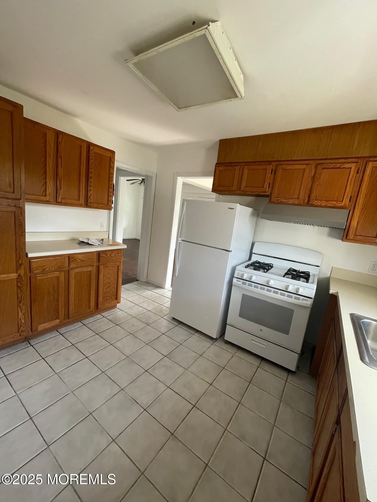 399 Park Avenue, Unit 1 Oakhurst, NJ 07755 - Photo 4 of 12 a kitchen with stainless steel appliances a stove a sink and a refrigerator