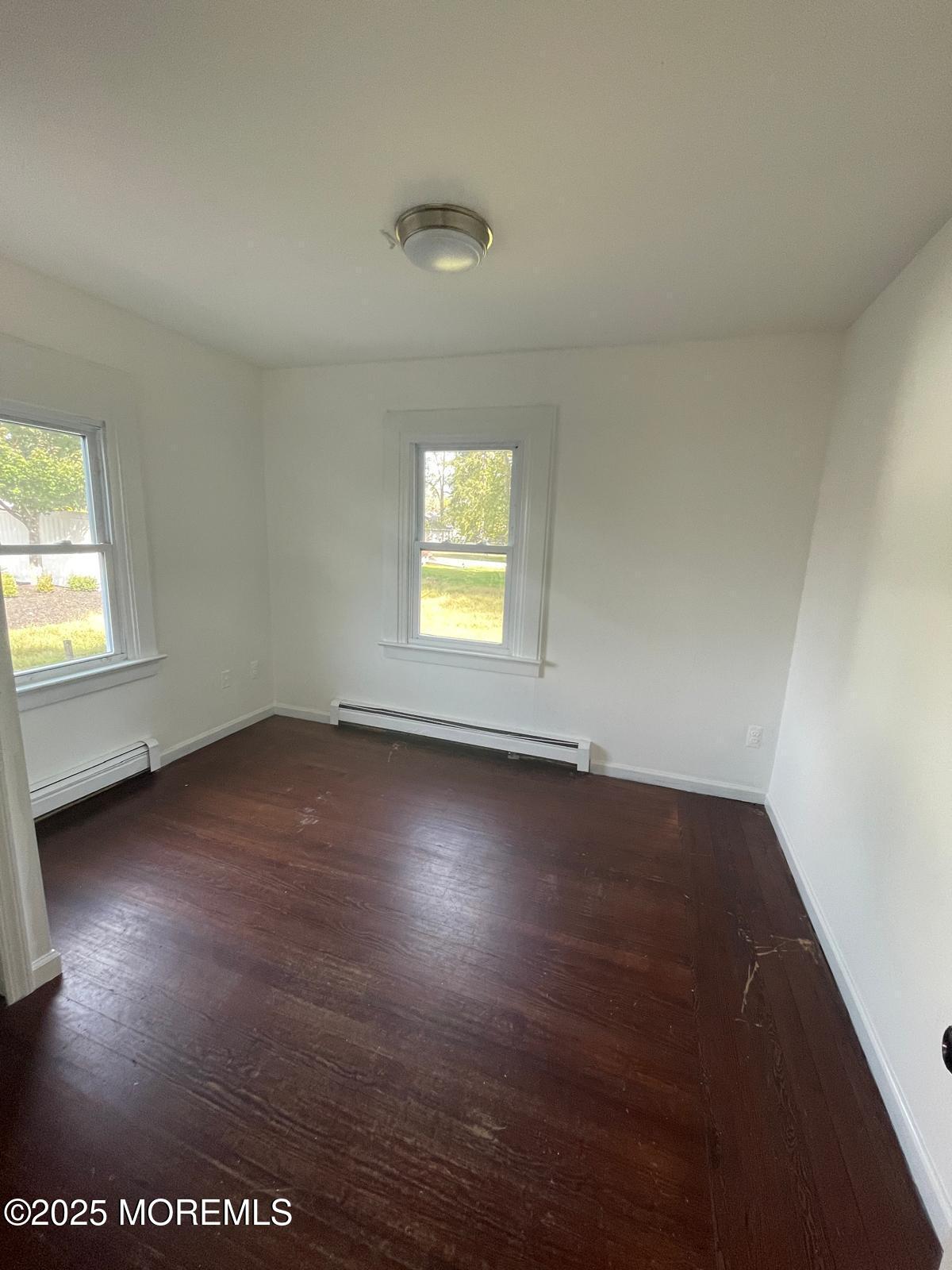399 Park Avenue, Unit 1 Oakhurst, NJ 07755 - Photo 10 of 12 an empty room with wooden floor and windows
