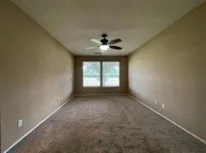 an empty room with windows and a ceiling fan
