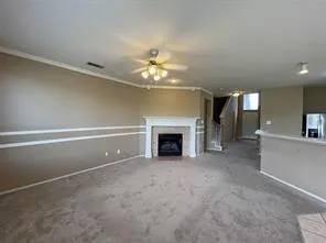 a view of a livingroom with a fireplace and a chandelier fan
