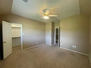 an empty room with closet and a ceiling fan