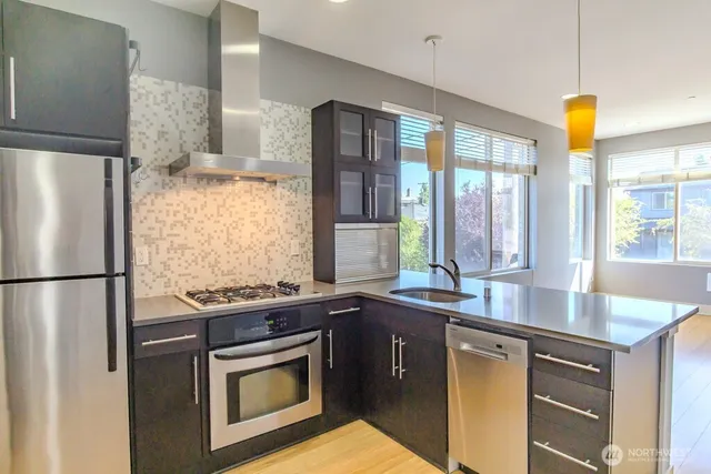 a metallic refrigerator freezer sitting in a kitchen