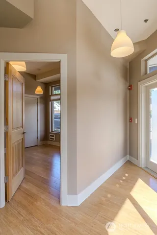 a view of a hallway with wooden floor and a chandelier