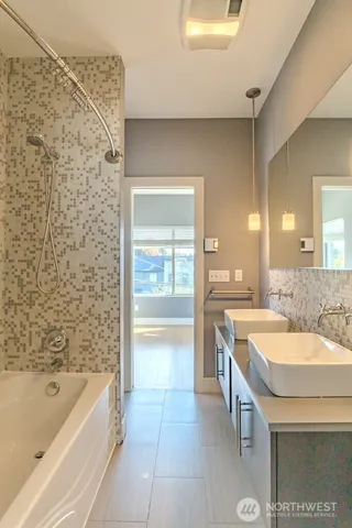 a bathroom with a granite countertop sink mirror and a bathtub