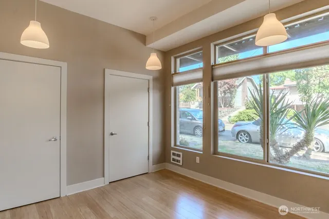 an empty room with wooden floor and windows