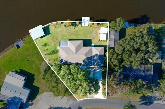 an aerial view of a house with pool outdoor seating and green space