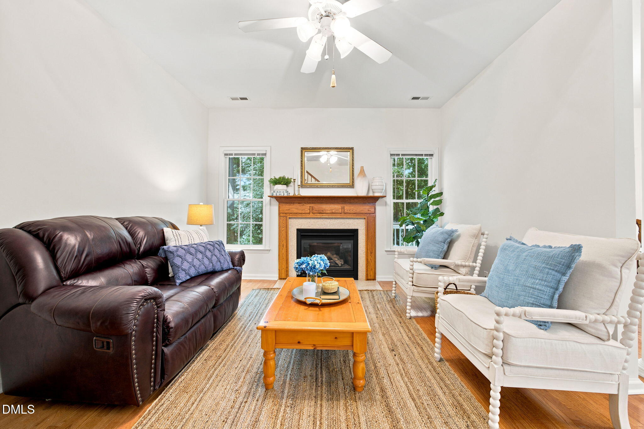 8211 Hempshire Place, Unit 104 Raleigh, NC 27613 - Photo 7 of 34 Living area featuring a fireplace with a wood mantle and hearth, two windows, and wood-finish flooring