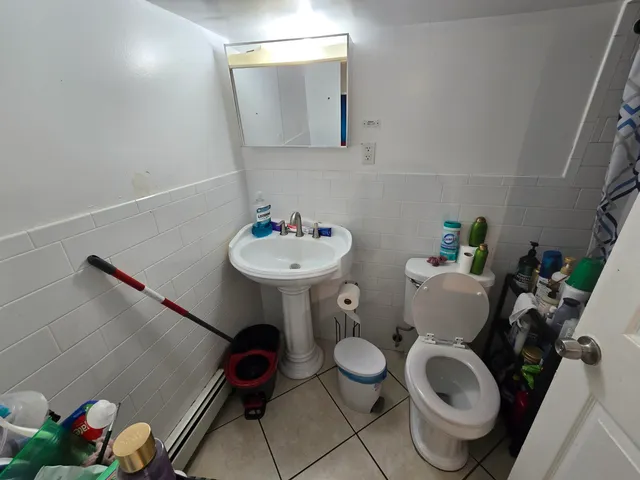 a bathroom with a toilet sink and mirror