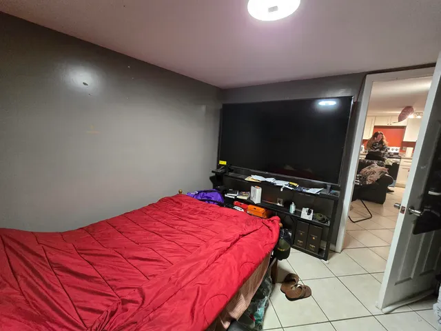 a bedroom with a bed and a flat screen tv
