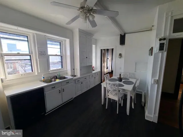 a room with stainless steel appliances kitchen island granite countertop furniture a sink a refrigerator and a window