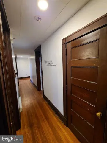 a view of hallway with stairs and wooden floor