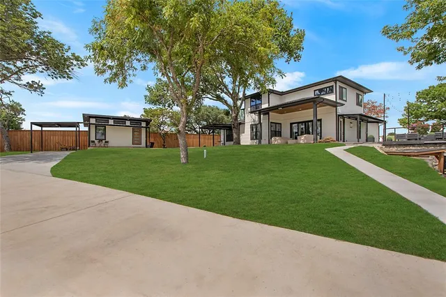 a front view of a house with a yard and trees