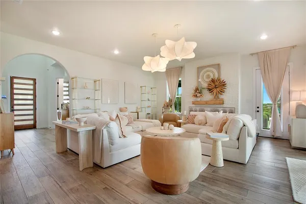 a living room with furniture a wooden floor and a chandelier