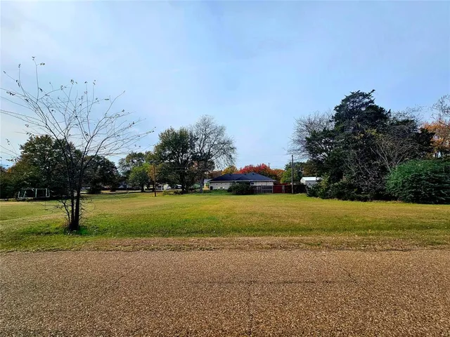 a view of a swimming pool with lawn chairs and a big yard
