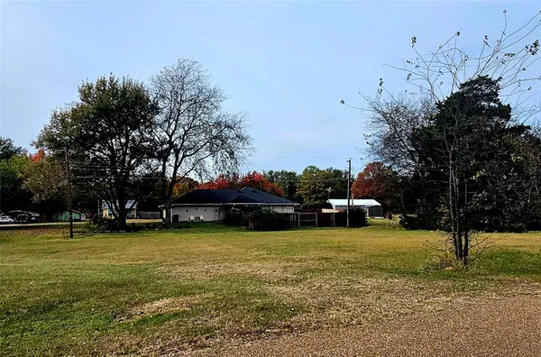 a view of a field of grass and trees