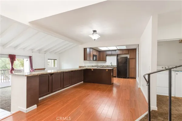 a large kitchen with granite countertop a large counter top space a sink and stainless steel appliances