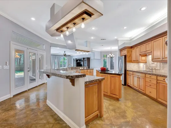 a kitchen with kitchen island a sink a counter top space and stainless steel appliances