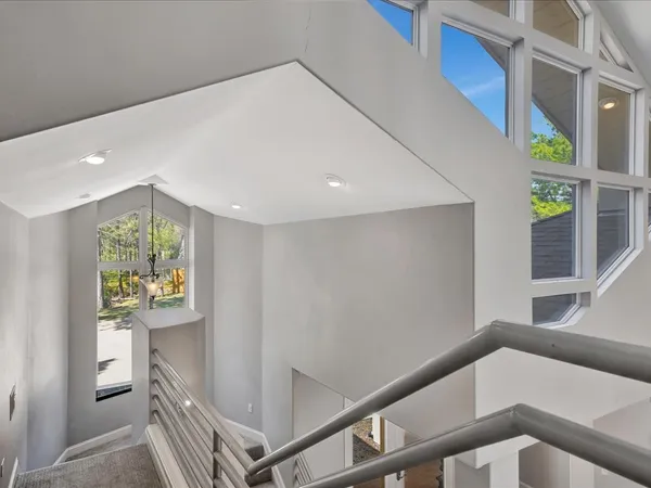 an empty room with windows and ceiling fan