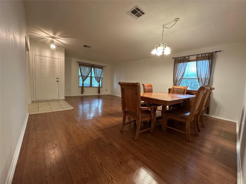 3412 Napa Valley Bend Leander, TX 78641 - Photo 26 of 27 Dining area featuring dark wood finished floors and a chandelier