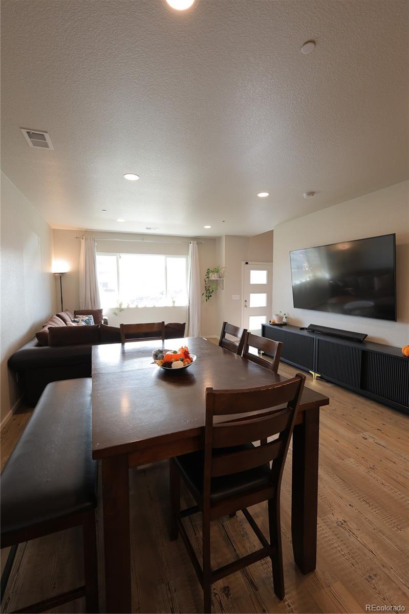 6719 4th St Road, Unit 2 Greeley, CO 80634 - Photo 4 of 23 a kitchen with a dining table chairs and flat screen tv
