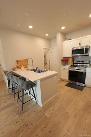 a kitchen with stainless steel appliances a microwave a stove a sink a microwave and a refrigerator