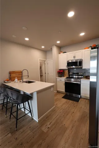 a kitchen with a dining table chairs and refrigerator