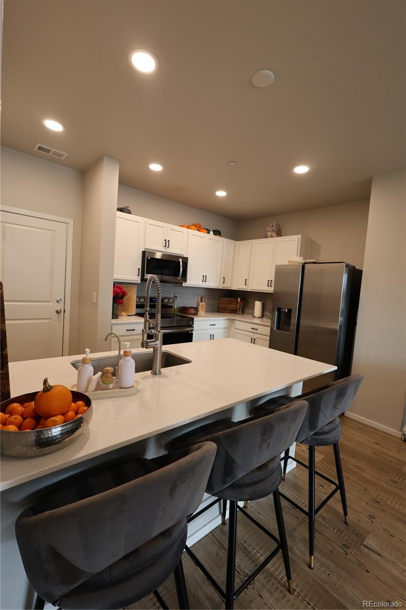 6719 4th St Road, Unit 2 Greeley, CO 80634 - Photo 7 of 23 a kitchen with a dining table chairs and refrigerator