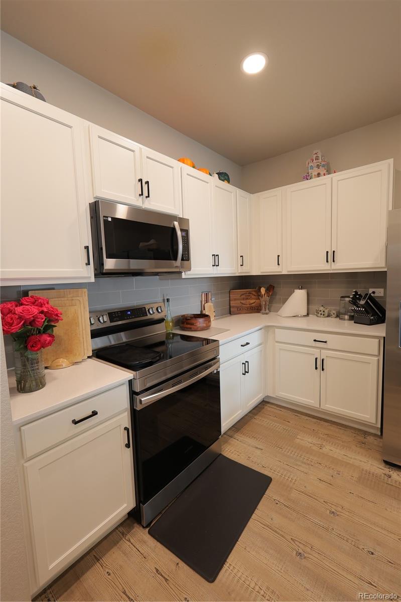 6719 4th St Road, Unit 2 Greeley, CO 80634 - Photo 8 of 23 a kitchen with granite countertop a sink cabinets and stainless steel appliances