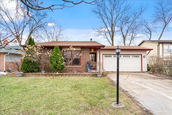 a front view of a house with a yard and potted plants