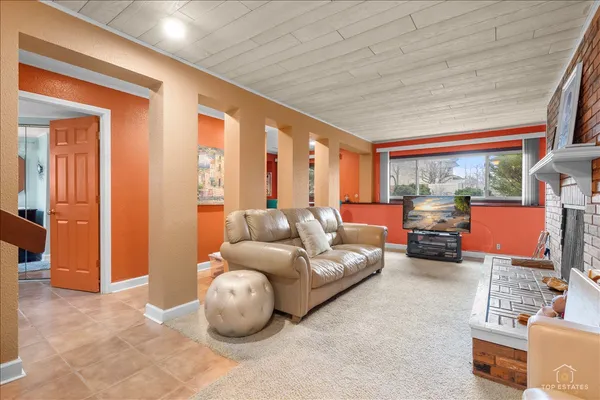 a living room with furniture a fireplace and a flat screen tv