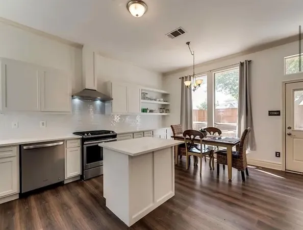 a kitchen with stove a table and chairs