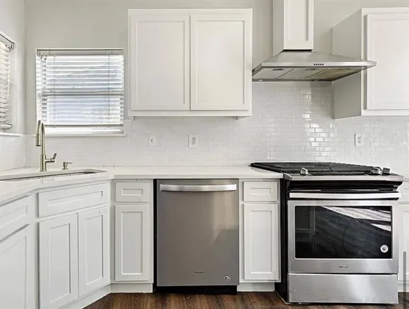 a kitchen with white cabinets and white appliances