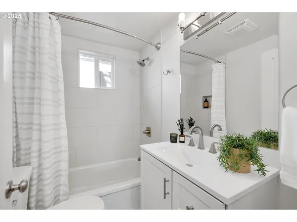 a bathroom with a sink vanity granite tub shower and a mirror