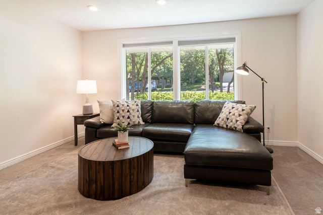 9676 Mt Jordan Road Sandy, UT 84092 - Photo 8 of 38 Bright living area featuring a large window, recessed lighting, neutral wall paint, and gray carpet flooring