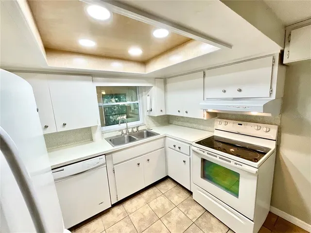 a kitchen with white cabinets and white appliances