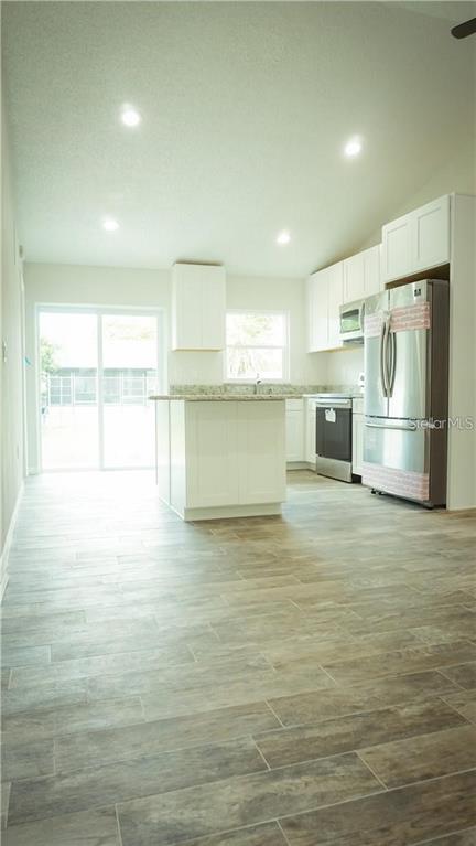 3409 Vidal Street New Port Richey, FL 34655 - Photo 4 of 8 a view of kitchen and empty room with wooden floor