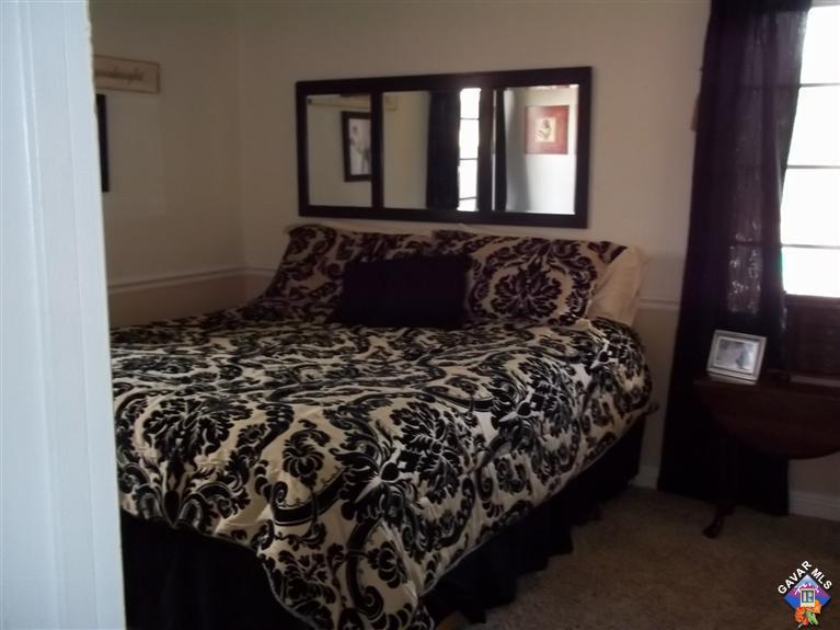 43940 3rd Street East Lancaster, CA 93535 - Photo 12 of 18 a bed sitting in a bedroom next to a window