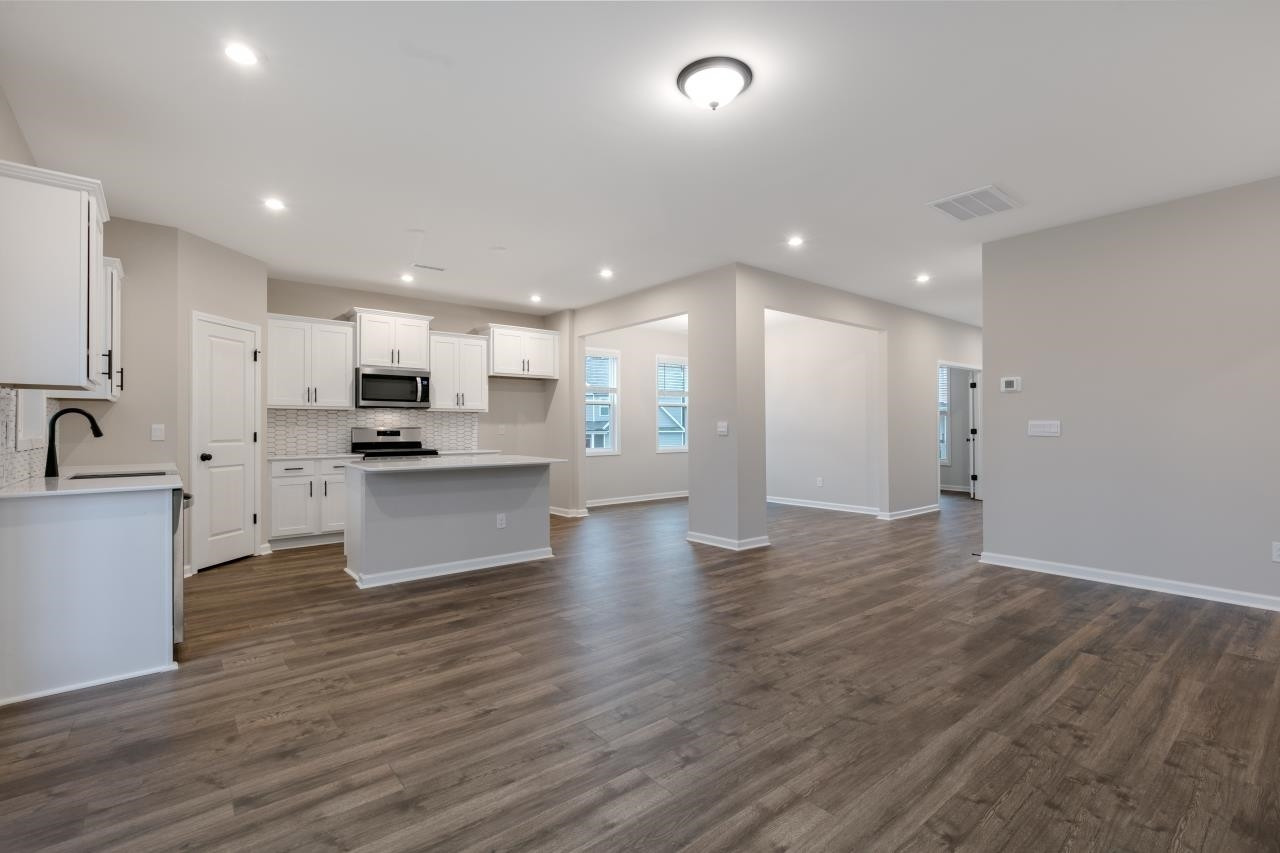 195 Madden Rose Loop Garner, NC 27529 - Photo 16 of 37 a view of kitchen with refrigerator sink and wooden floor