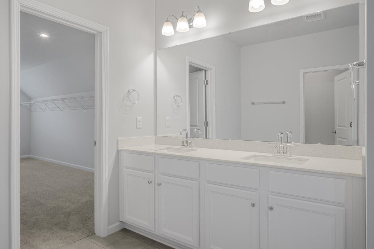 195 Madden Rose Loop Garner, NC 27529 - Photo 33 of 37 a bathroom with a double vanity sink and a mirror