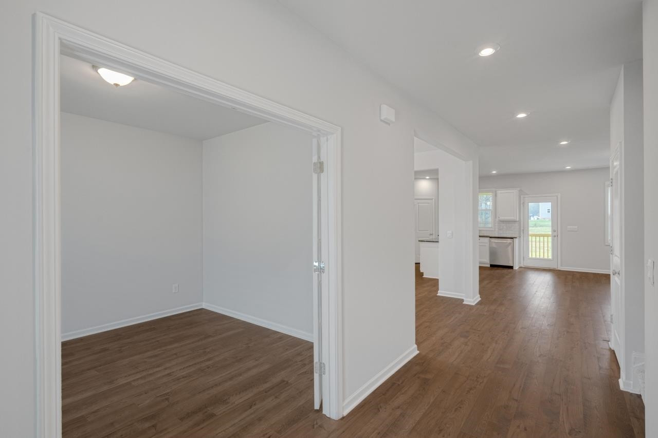 195 Madden Rose Loop Garner, NC 27529 - Photo 8 of 37 a view of a big room with wooden floor and windows