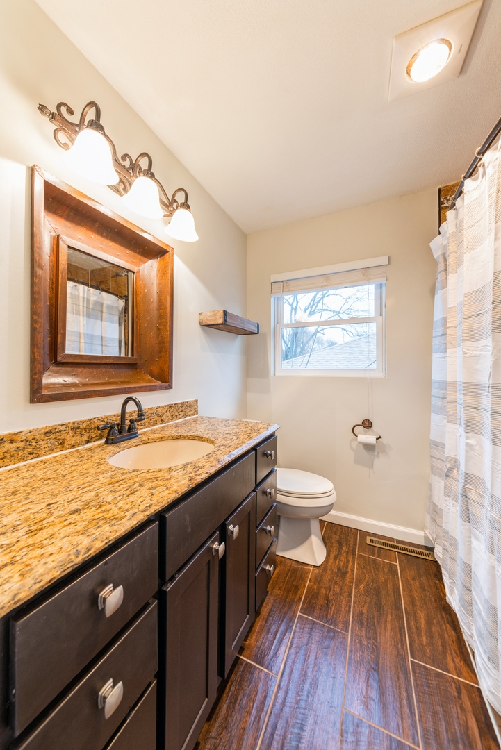 219 North Butterfield Road Libertyville, IL 60048 - Photo 11 of 14 a bathroom with a granite countertop sink toilet a large mirror and shower