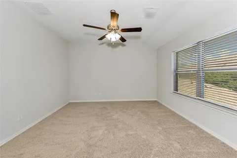 an empty room with windows and fan