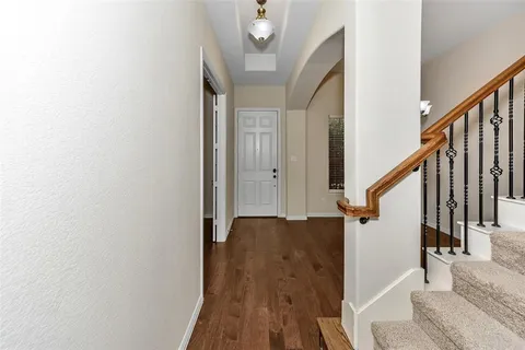 a view of a hallway with wooden floor and staircase