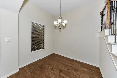a view of a room with wooden floor and a window