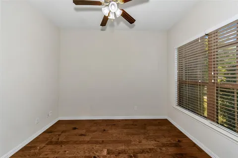 a view of a room with wooden floor and ceiling fan
