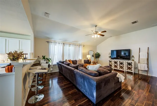 a living room with furniture a flat screen tv and a fireplace