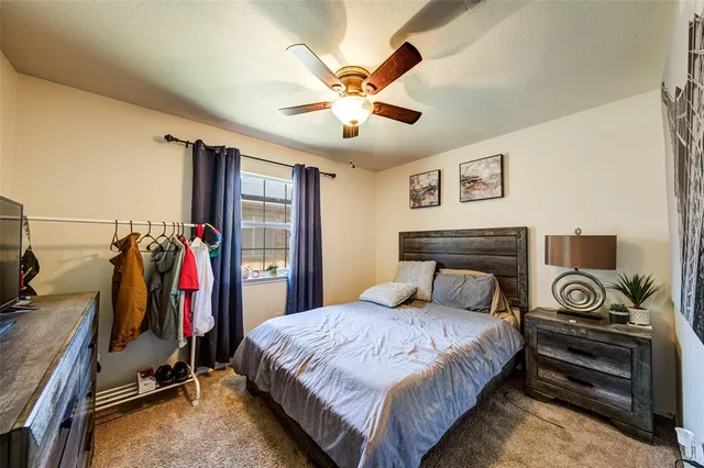 a bed room with a bed and a ceiling fan