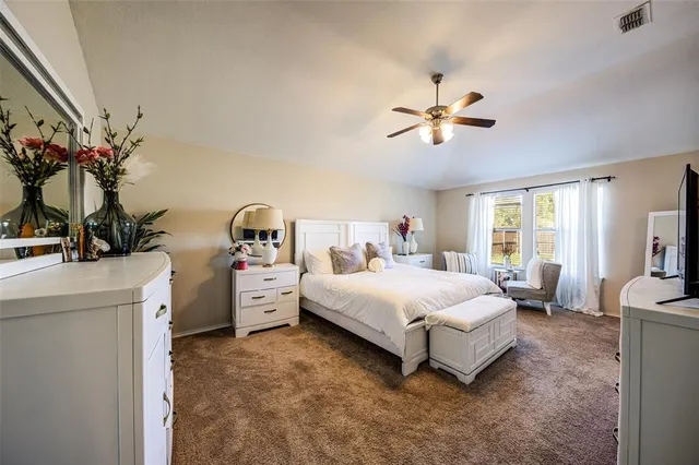 a spacious bedroom with a bed and a chandelier