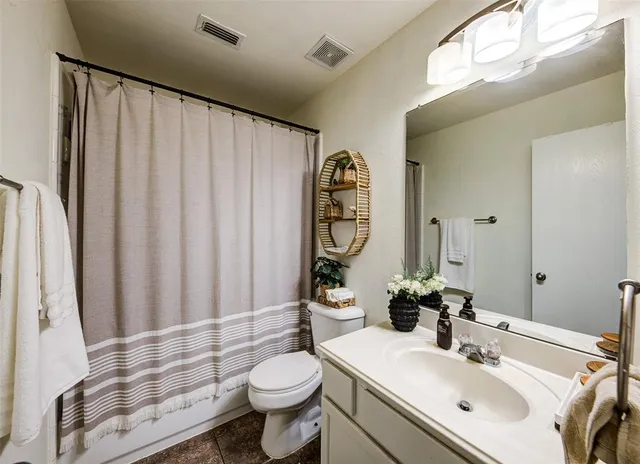 a bathroom with a sink a toilet and shower curtain