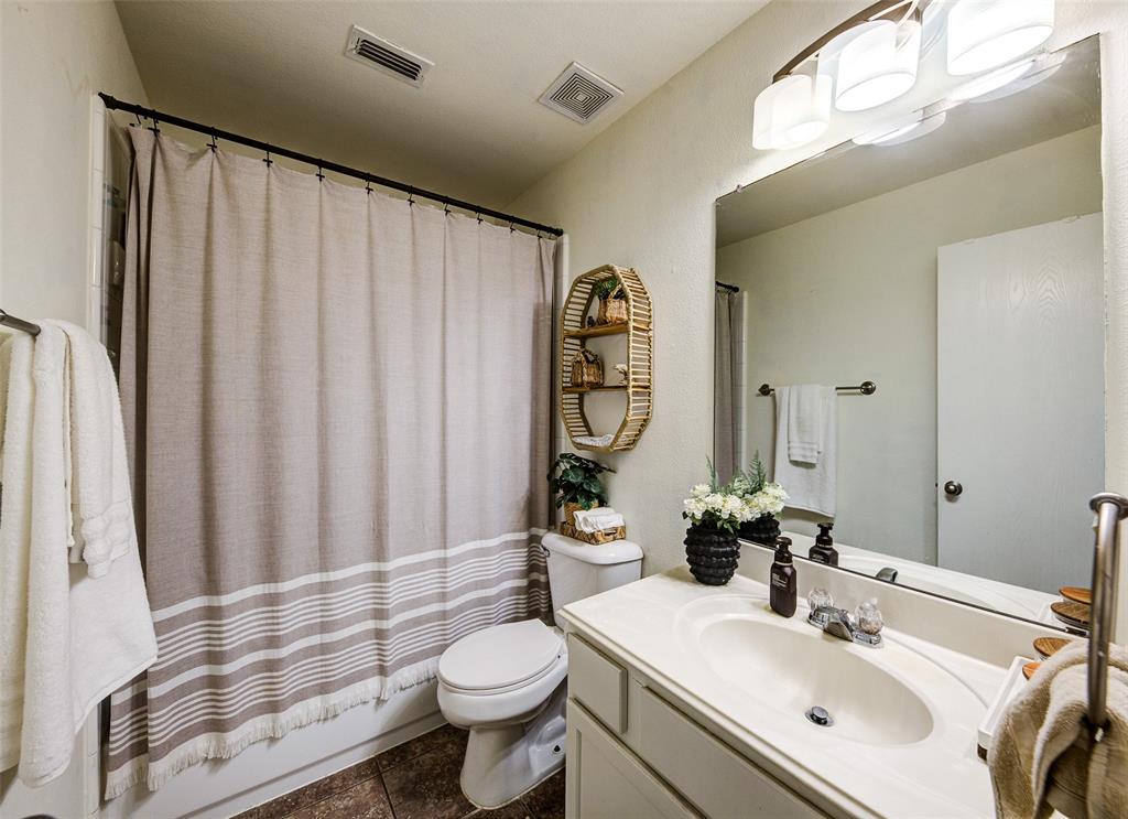 8817 King Ranch Drive Cross Roads, TX 76227 - Photo 20 of 24 a bathroom with a sink a toilet and shower curtain
